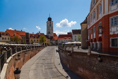 Sibiu, Transilvanya, Romanya - 2 Mayıs 2022: Piata Mica veya Yalanlar Köprüsü 'nden The Small Square view, Sibiu' nun tarihi merkezi. Turnul Sfatului - halka açık tarihi kule. Güneşli bir gün.