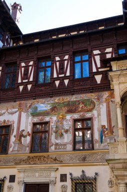 Peles Kalesi 'nin iç avlu cephesi, alegorik elle boyanmış duvar resimleri ve fachwerk ile süslenmiş. Romanya 'nın Sinaia, Karpat Dağları kenti.