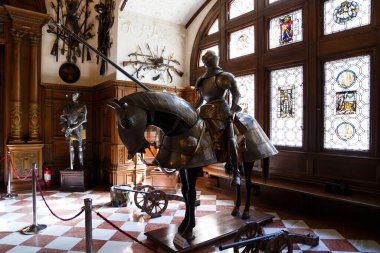 Sinaia, Romanya - 26 Ağustos 2022: Zırhlı Şövalye ve Büyük Cephanelik Salonu 'nda Peles Kalesi' nin içinde kılıç. Romanya 'nın Sinaia kentindeki Peles Ulusal Müzesi' nin zengin iç kesimi