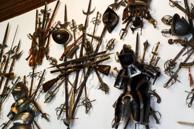 Sinaia, Romanya - 26 Ağustos 2022: Peles Kalesi 'ndeki duvarda çeşitli silah ve zırhların koleksiyonu. Romanya 'nın Sinaia kentindeki Peles Ulusal Müzesi' nin zengin iç kesimi.