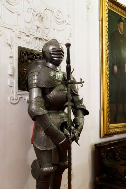 Sinaia, Romanya - 26 Ağustos 2022: Zırhlı bir şövalye ve Peles Kalesi 'nin içindeki salonda kılıcı var. Romanya 'nın Sinaia kentindeki Peles Ulusal Müzesi' nin zengin iç kesimi