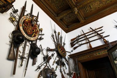 Sinaia, Romanya - 26 Ağustos 2022: Peles Kalesi 'ndeki duvarda çeşitli silah ve zırhların koleksiyonu. Romanya 'nın Sinaia kentindeki Peles Ulusal Müzesi' nin zengin iç kesimi.