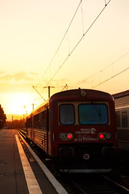 Brasov, Romanya - 26 Ağustos 2022: Günbatımında Brasov tren istasyonunda insanlar olmadan yolcu treni Gara Brasov. Romanya Demiryolları.