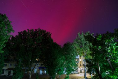 Odesa, Ukrayna - 11 Mayıs 2024: Ukrayna 'nın güneyindeki Odessa şehrinde gece gökyüzünde kırmızı renkli Aurora Borealis veya Kuzey Işıkları. Güneş maksimumu sırasında düşük enlemlerde Aurora