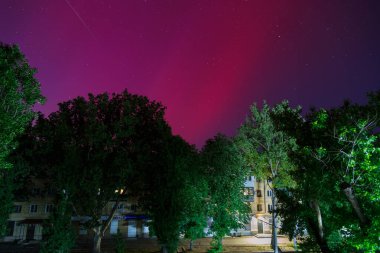 Odesa, Ukrayna - 11 Mayıs 2024: Ukrayna 'nın güneyindeki Odessa şehrinde gece gökyüzünde kırmızı renkli Aurora Borealis veya Kuzey Işıkları. Güneş maksimumu sırasında düşük enlemlerde Aurora