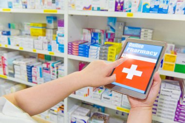 Eczanede reçeteyi doldurmak için bilgisayar tableti tutan eczacı.