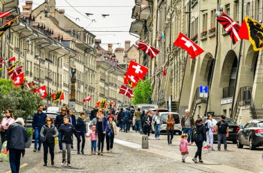 Bern-20 Mayıs 2023: Bern İsviçre 'de Kramgasse caddesinde turistlerin ve Zytglogge saat kulesinin olduğu eski kasaba manzarası