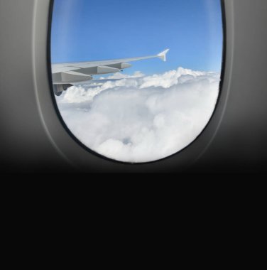 Bir uçak penceresinden bulutların ve kanadın görüntüsü.