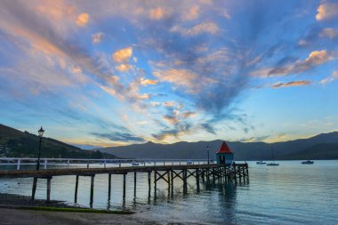 Akaroa Limanı, Yeni Zelanda 'da dağların ardında gün batımı