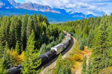 Kanada Rocky Dağları, Banff Ulusal Parkı, Kanada Rocky Dağları 'ndaki Bow nehri boyunca giden uzun bir yük treni..