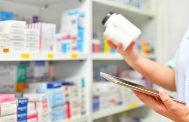 Eczanede reçeteyi doldurmak için bilgisayar tableti tutan eczacı. Çevrimiçi tıbbi konsept