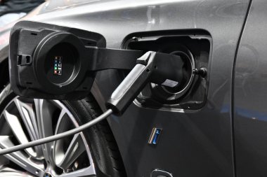 Elektrikli araç şarj edilen bir elektrikli arabaya takılı güç kaynağı ile istasyonda şarj oluyor..