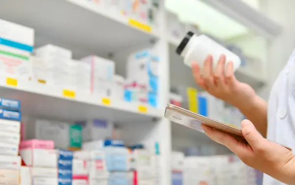 Pharmacist holding computer tablet Using for filling prescription in pharmacy drugstore. Online medical concept