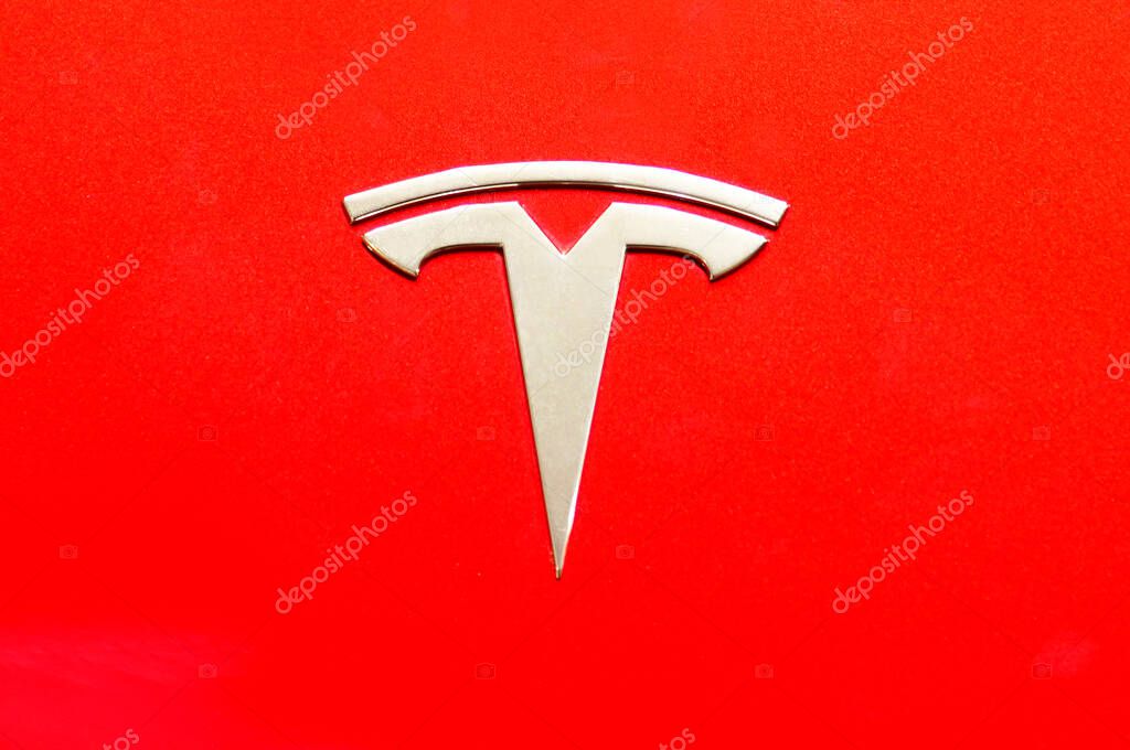 Bangkok ,Thailand ,May -15, 2024 : Close up of Tesla logo on tesla model 3 red background at dealer showroom in siam paragon