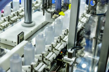 Yüksek kalite otomatik dolgu makinesinde, taşıyıcı bantta beyaz plastik şişeler. Fabrika üretim hattında.