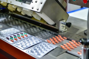 Üretim sırasında kapsül ilaç hapları ve modern ilaç fabrikası Tıbbi İlaç Üretimi 'nde ambalaj süreci.