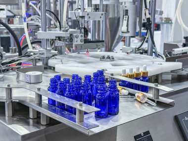 Yüksek kalite otomatik dolgu makinesinde taşıyıcı bantta cam şişeler. Fabrika üretim hattında.