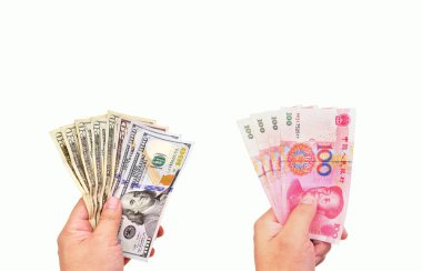 Beyaz arka planda ABD Doları ve Çin Yuan banknotunu tutan iki el
