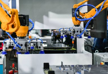 Robot kolu, sanayi fabrikasındaki çelik levha kesme işlemini kontrol ediyor.