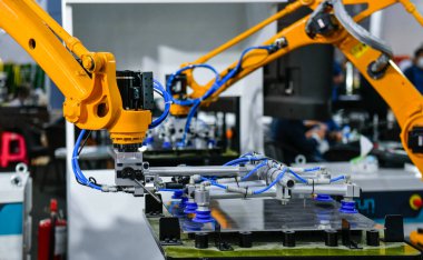 Robot kolu, sanayi fabrikasındaki çelik levha kesme işlemini kontrol ediyor.