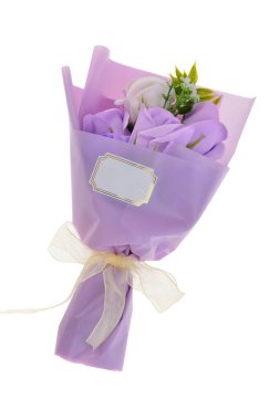 Beyaz arka planda izole edilmiş bir hediye çantasındaki mor güller.