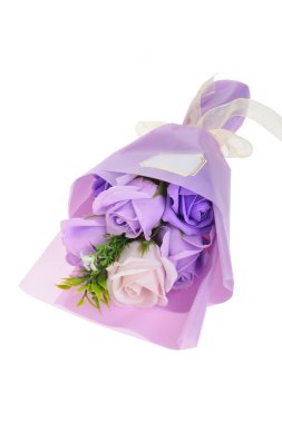 Beyaz arka planda izole edilmiş bir hediye çantasındaki mor güller.