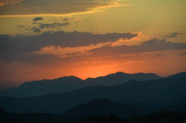 Yazın dağların ardında güzel bir günbatımı.