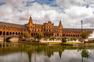 SEVILLA, İSPA - Haziran 2020. Seville 'deki İspanya Meydanı Plaza de Espana Panoraması' nda kanal, göl, çeşme, kuleler ve binanın ana girişi üzerinde köprüler bulunmaktadır. Mağribi ve Rönesans canlandırması örneği.