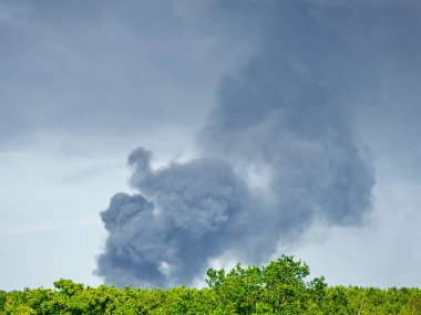 Yanan bir plastik geri dönüşüm yeri, gökyüzü mavi yaz gününde koyu siyah bir duman yığınına neden olur. Tehlike, keder. Terörist saldırı ya da patlama. Çevre felaketi