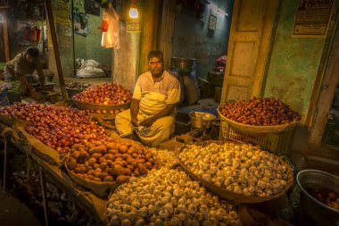 PUDUCHERRY, Hindistan - Mart 2019. Gece vakti sebze satan tanımlanamayan bir sokak satıcısı. Sessiz atmosfer ve sıcak renkler.
