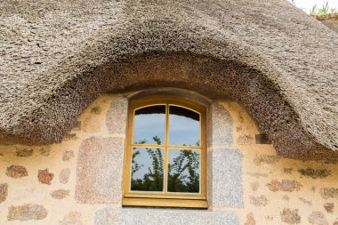 Close-up of cottage with dormer thatched roof