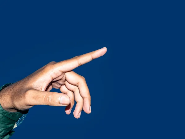 Close up of a young indian man hand pointing finger as touching screen, isolated on blue background. Innovation technology internet business concept background for graphic designer