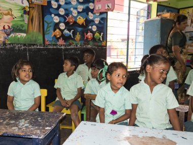 PUDUCHERRY, İNDİA - Aralık 2018. Tanımlanamayan mutlu öğrenciler devlet okulu üniformalı sınıf arkadaşları evde oturup ders çalışıyorlar. Yardım için gülümseyen zavallı gençlerin portresi..