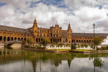 SEVILLA, İSPA - Haziran 2020. Seville 'deki İspanya Meydanı Plaza de Espana Panoraması' nda kanal, göl, çeşme, kuleler ve binanın ana girişi üzerinde köprüler bulunmaktadır. Mağribi ve Rönesans canlandırması örneği.