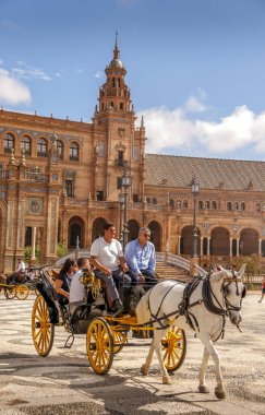 SEVILLE, İSPAN - Haziran 2020. İspanya Meydanı 'ndaki Plaza de Espana at arabasında turist gezintisi. 1929' daki İbero-Amerikan Sergisi için Anibal Gonzalez tarafından tasarlandı. Coronavirüs yüzünden müşteri yok.