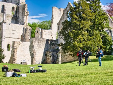 Jumieges, Fransa - Nisan 2019. Profesyonel film için tanımlanamayan kameramanlar. . Açık havada pan tilt shift profesyonel baş tripod üzerinde kayıt veya çekim tv ticari üretim yüksek çözünürlüklü dijital video kamera arka açı görünümü