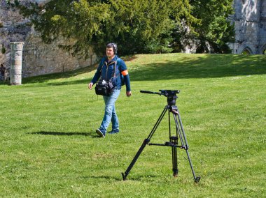 Jumieges, Fransa - Nisan 2019. Profesyonel film için tanımlanamayan kameramanlar. . Açık havada pan tilt shift profesyonel baş tripod üzerinde kayıt veya çekim tv ticari üretim yüksek çözünürlüklü dijital video kamera arka açı görünümü