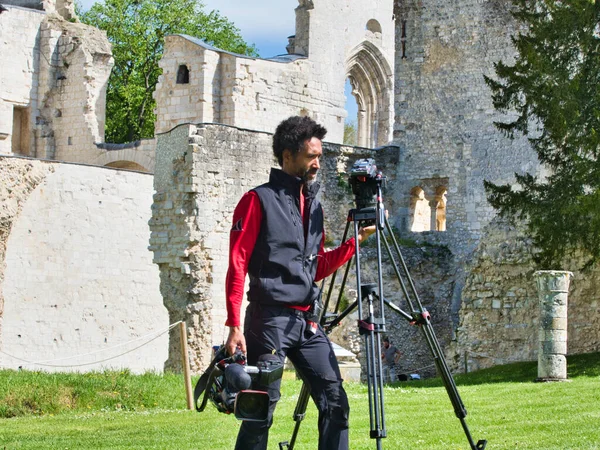 Jumieges, Fransa - Nisan 2019. Profesyonel film için tanımlanamayan kameramanlar. . Açık havada pan tilt shift profesyonel baş tripod üzerinde kayıt veya çekim tv ticari üretim yüksek çözünürlüklü dijital video kamera arka açı görünümü