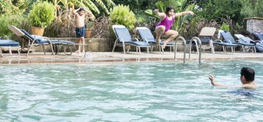 Üç mutlu gençler kardeşler kardeş Resort yüzme havuza atlama. Zaman birlikte suç tatil harcama yaz ışık tatili