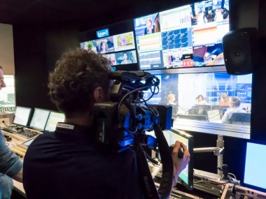 PARIS, FRANCE- Kasım 2019 civarı. Teknik odada ses karıştırma konsolu olan kameraman, bilgisayarlar, televizyon, ekran ve stüdyo ekipmanları kayıt, yayın, düzenleme stüdyolarında. İki ses mühendisiyle.
