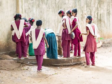 Puducherry, Tamil Nadu, Hindistan - Aralık yaklaşık, 2018. Yemeden önce kuyu onların plaka temizlemek için tanımlanamayan zavallı sınıf çocuklarla üniformalar kuyruk açık havada. Öğle yemeği zamanı, genel hükümet okulda sağlıksız gıda