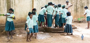 Puducherry, Tamil Nadu, Hindistan - Aralık yaklaşık, 2018. Yemeden önce kuyu onların plaka temizlemek için tanımlanamayan zavallı sınıf çocuklarla üniformalar kuyruk açık havada. Öğle yemeği zamanı, genel hükümet okulda sağlıksız gıda