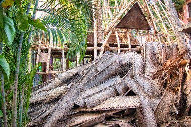 Çapulcu, TAMIL NADU - Aralık 2018. Tanımlanamayan Hintli işçiler turistlere servis yapmak için odunluğun tepesini hindistan cevizi yapraklarıyla kapladılar. Dalit halkı için zor bir iş.