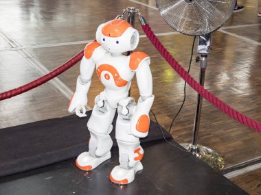 Bilim Merkezi, Paris, Fransa - Kasım 2019. İnsan yüzü ve vücudu olan küçük bir robot. İnsansı. Yapay Zeka, yapay zeka. Turuncu ve beyaz robot.