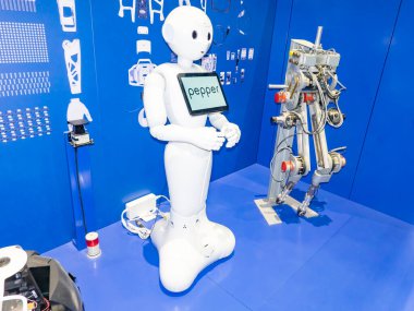 SCIENCE CENTER, PARIS, FRANCE - NOVEMBER Circa, 2019. Pepper robot. Pepper is a humanoid robot by Aldebaran Robotics and SoftBank designed with the ability to read emotions. Drawing on blue wall to understand conception of robot clipart