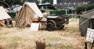Aziz Michael L 'Eglise, Normandiya, Fransa - 6 Haziran 2023. İkinci Dünya Savaşı anısına. Askeri kamp yeniden yapılandırması Kimliği belirsiz askerler askeri Amerikan savaş kamyonlarının yanında.