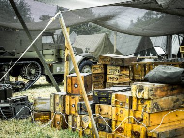SAINTE MERE L'EGLISE, NORMANDY, FRANCE - JUNE 6 2023. Second world war commemoration. Military camp reconstitution Ammunition in many wood boxes under tents clipart