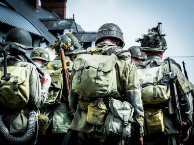 Aziz Michael L 'Eglise, Normandiya, Fransa - 6 Haziran 2023. İkinci Dünya Savaşı anısına. Askeri kamp yeniden yapılandırıldı. Tanımlanamayan silahlı askerler özgürlükten sonra yürüyorlar