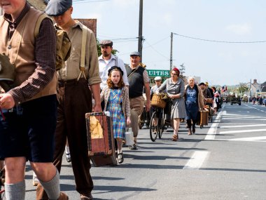 Aziz Michael L 'Eglise, Normandiya, Fransa - 6 Haziran 2023. İkinci Dünya Savaşı anısına. Tanımlanamayan vintage giyimli kırsal aileler savaş nedeniyle göç ediyor. Doğum günü özgürlüğünün yeniden düzenlenmesi.