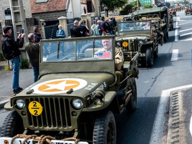 Aziz Michael L 'Eglise, Normandiya, Fransa - 6 Haziran 2023. İkinci Dünya Savaşı anısına. Askeri kamp yeniden yapılandırıldı. Tanımlanamayan silahlı askerler özgürlükten sonra yürüyorlar